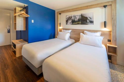 two beds in a hotel room with blue walls at Best Western Kobalt Annecy Nord - Epagny in Épagny