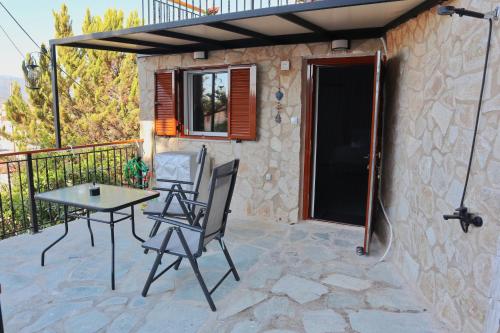 a patio with a table and chairs on a balcony at Arokaria Studio in Paralion astros