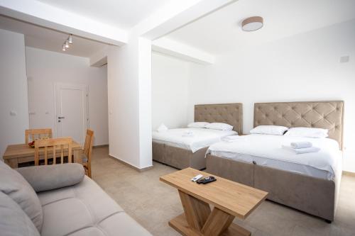 two beds in a room with a couch and a table at Apartmani Milos - Meljine in Herceg-Novi