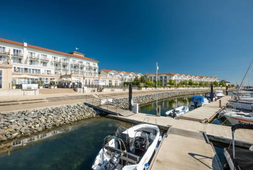 a group of boats docked in a marina next to a building at Lindner Hotel Boltenhagen, part of JdV by Hyatt in Boltenhagen