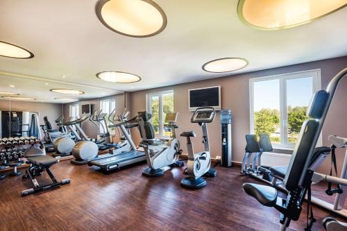 a gym with treadmills and cardio equipment in a room at Lindner Hotel Boltenhagen, part of JdV by Hyatt in Boltenhagen