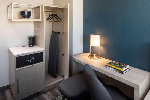 a room with a desk with a chair and a lamp at Hyatt Place New York Chelsea in New York