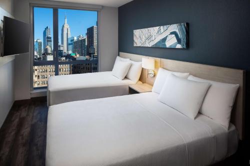 a hotel room with two beds and a window at Hyatt Place New York Chelsea in New York