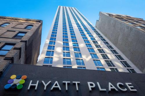 ニューヨークにあるHyatt Place New York Chelseaのハイアットサイン付高層ビル