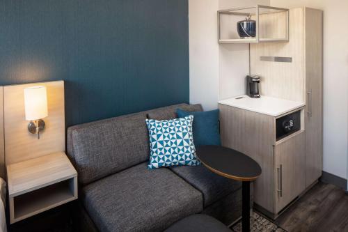 a small living room with a couch and a table at Hyatt Place New York Chelsea in New York