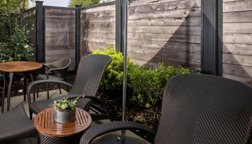 a patio with chairs and a table and a fence at Bardessono Hotel and Spa in Yountville