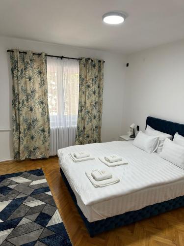 a bedroom with a large bed with two towels on it at M2-apartments in Kraljevo