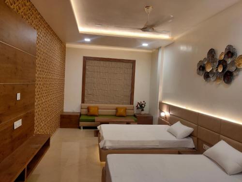 a room with two beds and a couch in it at RIVERSIDE MEADOWS in Vidisha