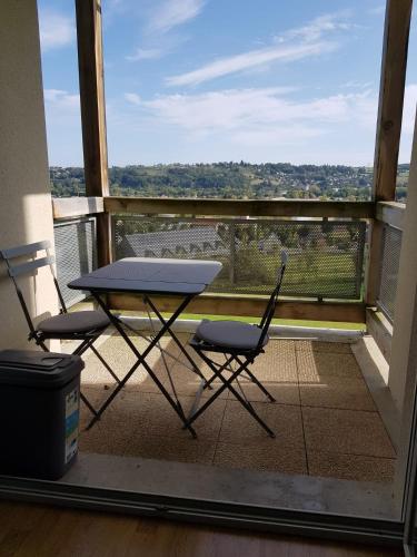 une table et deux chaises sur un balcon dans l'établissement Soleil 65, à Bagnères-de-Bigorre
