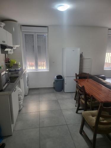 une cuisine avec une table, des chaises et un réfrigérateur dans l'établissement Aubervilliers, à Aubervilliers