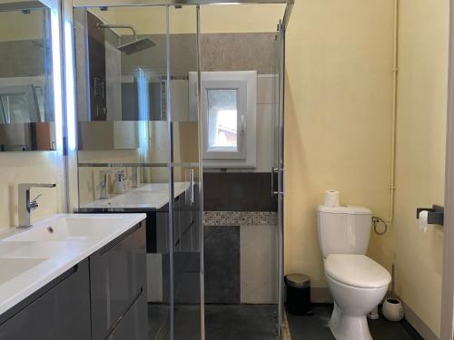 a bathroom with a toilet and two sinks and a shower at Résidence Verdi - Appartements meublés en centre ville in Bédarieux