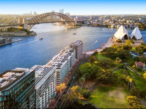a view of a river with a bridge and buildings at Luxurious Apartment only 250m Walk To Opera House in Sydney