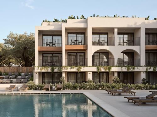 an apartment building with a swimming pool and a resort at Planos Deluxe in Zakynthos Town