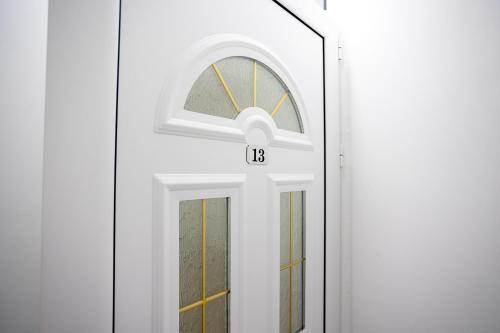 a white door with a window and a letter b on it at Apartmani Milos - Meljine in Herceg-Novi