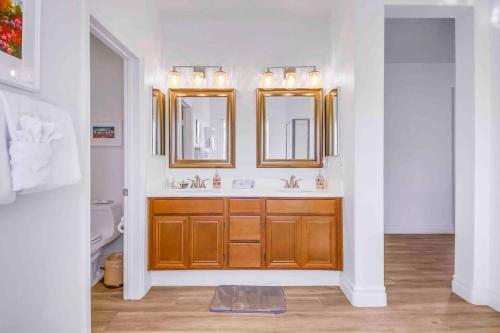 a bathroom with two sinks and two mirrors at SPLASH-TASTIC FUN HOUSE in Indio