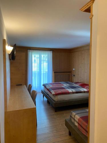 a bedroom with two beds and a window at Hotel Compagnoni in Santa Caterina Valfurva