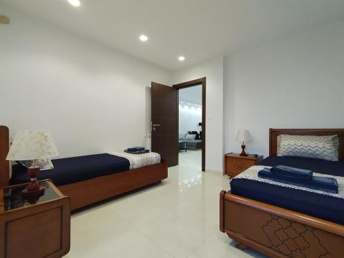 a bedroom with two beds and a mirror at Luxueux Appartement à Tlemcen in Tlemcen