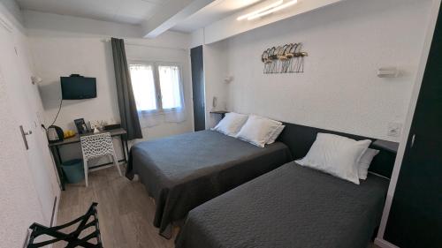 a small bedroom with two beds and a window at Hôtel Aragon - Centre ville gare in Perpignan