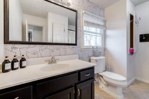 ein Badezimmer mit Waschbecken, Toilette und Spiegel in der Unterkunft Spacious House Near Savannah Airport - 5 BR in Savannah