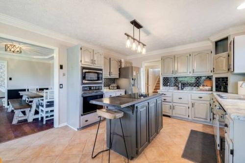 a kitchen with white cabinets and a large island at Spacious House Near Savannah Airport - 5 BR in Savannah