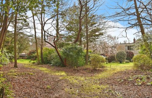 a garden with trees and bushes and a house at Brooklands Barn in Lower Swanwick
