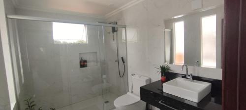 a bathroom with a shower and a toilet and a sink at Pousada da Paz in Curitiba
