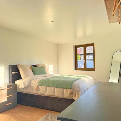 a bedroom with a large bed and a window at Grand appartement chaleureux in Steinbrunn-le-Bas