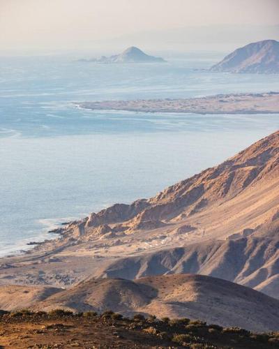 an aerial view of the ocean and mountains at Cabañas Alto Rincon de Atacama in El Barquito
