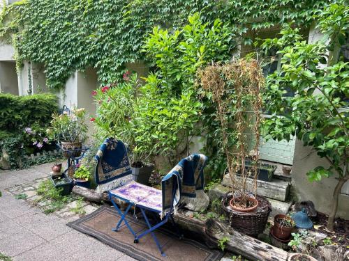 a garden with chairs and potted trees and plants at Maison de ville arborée avec cachet in Nanterre