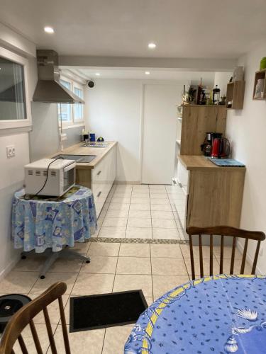 une petite cuisine avec une table et un micro-ondes dans l'établissement Rose des sables R d c, à Jullouville