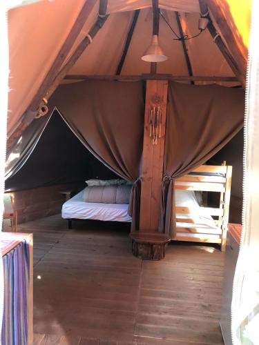 une chambre avec un lit dans une tente dans l'établissement Camping La Châtaigneraie, à Gravières