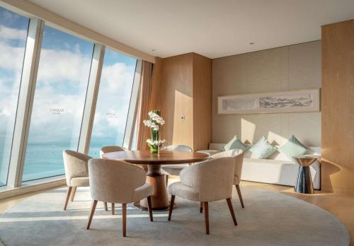 a dining room with a table and chairs and a couch at Conrad Xiamen in Xiamen
