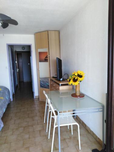 Cette chambre comprend un bureau avec un ordinateur et des chaises. dans l'établissement STUDIO PROCHE MER ETANGS ET CANAUX, à Mauguio