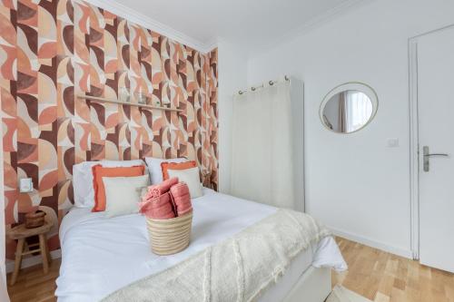 - une chambre avec un lit blanc et un mur à motifs dans l'établissement Maison 8 personnes - Parking - Métro 7 et Rer B à 6 minutes, à La Courneuve