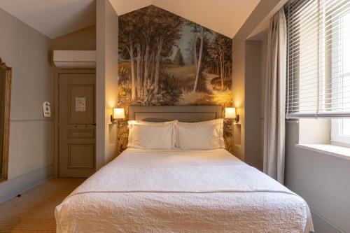 a bedroom with a bed and a painting on the wall at AlmaLusa Alfama in Lisbon