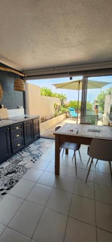 une cuisine avec une table et une vue sur un patio dans l'établissement Ile Rousse Guardiola T2 les pieds dans l eau, à Monticello