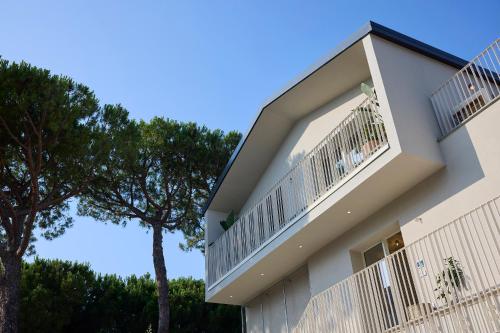 a building with a balcony and a tree at la Sfiora B&B in Cervia