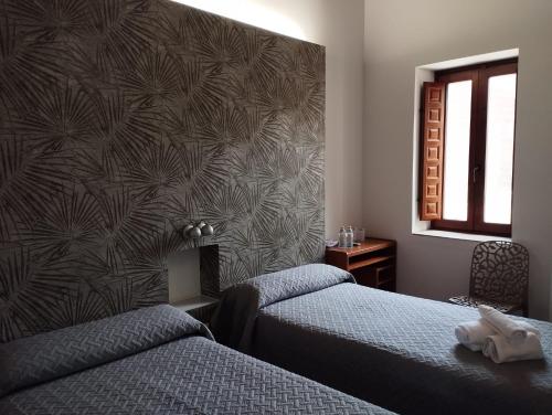 a hotel room with two beds and a window at Hotel-Restaurante Casa Blava Alzira in Alzira