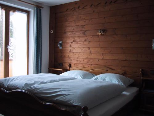 レッヒにあるHaus Feuersteinの木製の壁のベッドルーム1室(大型ベッド1台付)