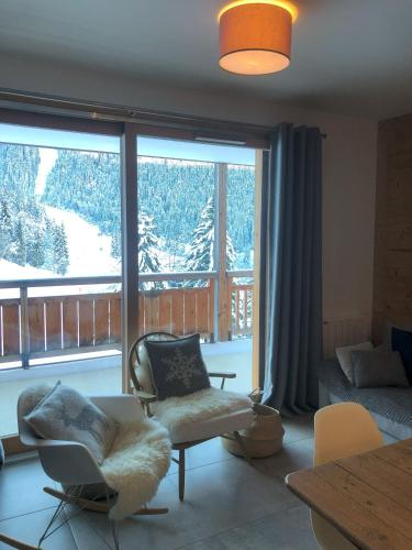 un salon avec une grande fenêtre avec vue dans l'établissement Appartement neuf, balcon plein sud, à Oz