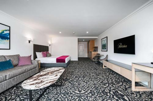 a hotel room with a couch and a bed at Quality Hotel Parklake Shepparton in Shepparton