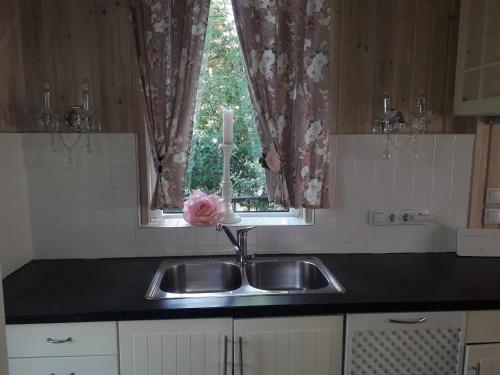 a kitchen with a sink and a window at Apartment Aloe in Jūrmala