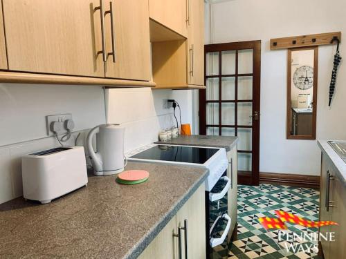 a kitchen with a sink and a counter top at The Old Courthouse Cottage, Haltwhistle in Haltwhistle