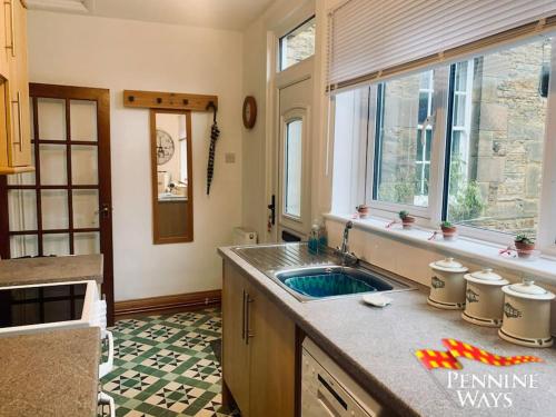 una cucina con un lavandino e una finestra di The Old Courthouse Cottage, Haltwhistle a Haltwhistle