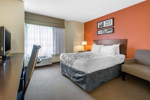 a hotel room with a bed and a television at Sleep Inn Sarasota North in Sarasota