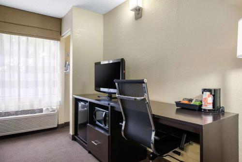 a room with a desk with a television and a chair at Sleep Inn Sarasota North in Sarasota