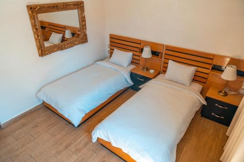 two beds in a room with a mirror at Hotel D'Europe Centre Ville in Kenitra