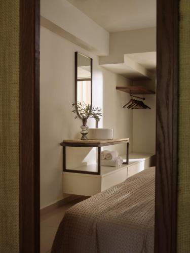 a bedroom with a table with a mirror and a bed at Planos Deluxe in Zakynthos Town