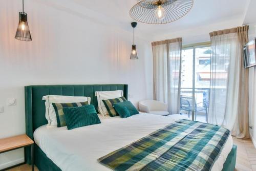 - une chambre dotée d'un grand lit avec des oreillers bleus et verts dans l'établissement Hypercentre - 5mn croisette - Palais - Plage - CF, à Cannes