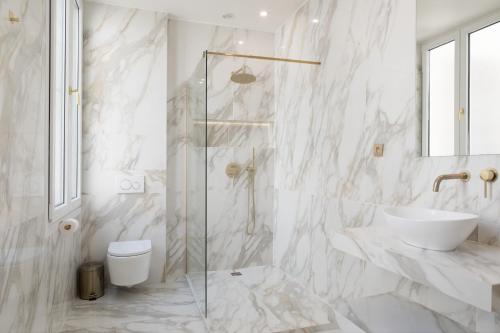 une salle de bain blanche avec un lavabo et une douche dans l'établissement Pick A Flat's Apartment in Le Marais - Rue des Gravilliers, à Paris